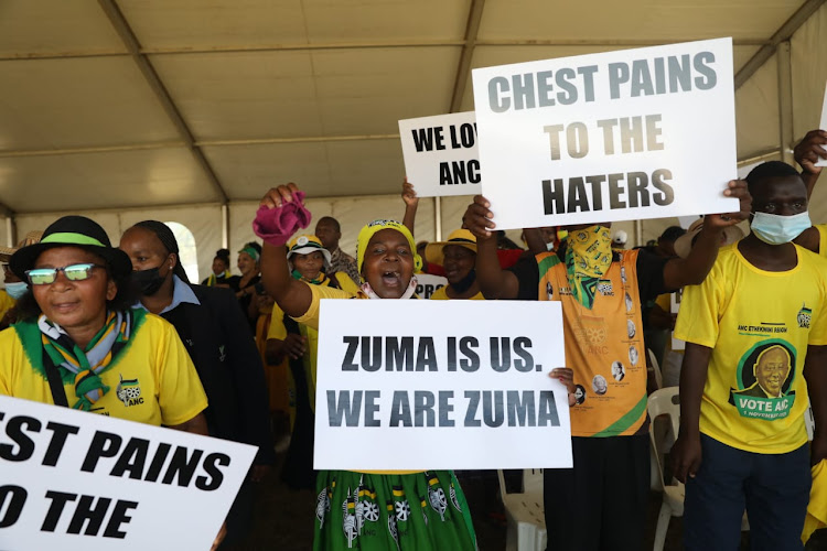 Supporters of former president Jacob Zuma hold placards during a prayer service for him after serving two months of his sentence for contempt of court.