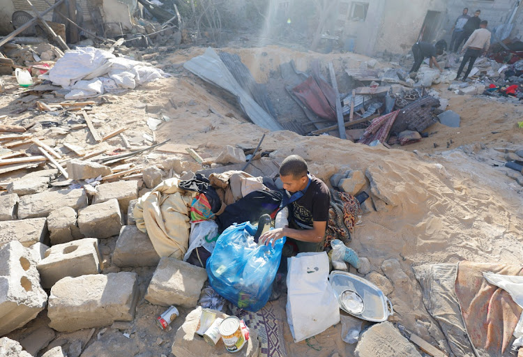 Palestinians inspect the site of an Israeli strike on a house, amid the ongoing conflict between Israel and the Palestinian Islamist group Hamas, in Rafah, in the southern Gaza Strip, May 8, 2024.