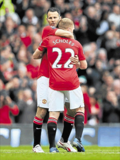 EVERGREEN: Paul Scholes of Manchester United is congratulated by teammate Ryan Giggs after scoring his team's second goal in the league match against Queens Park Rangers at Old Trafford on Sunday. Photo: Getty Images