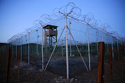 Chain link fence and concertina wire surrounds a deserted guard tower within Guantanamo's Camp Delta at the US naval base in Guantanamo Bay, Cuba, on March 21 2016. 