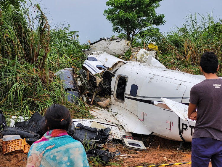 People look at the aircraft after it crashed, which has left 14 dead in Barcelos, Amazonas, Brazil, on September 16 2023.