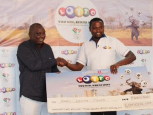 A file photo of Lotto customer receiving his winnings from Kenya CEO, Brian Waluchio. /COURTESY