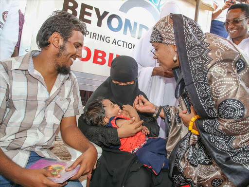 First Lady Margaret Kenyatta administers a vaccine on 6-month old Mustafa Mohammed Abeid when she presided over official inaugural hand-over of the 39th Fully-Kitted ‘Beyond Zero’ Mobile Clinic to Garissa County at Garissa Primary grounds.Photo PSCU