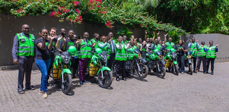 Group photo of Bolt, MKOPA, ROAM and Ampersand teams with the riders.