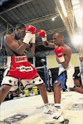 SILENCING THE CROWD: Toto Helebe, right, knocked out Phumzile Matyhila, left, for the SA bantamweight title at the  Orient Theatre in East London on Friday night.  PHOTO: YANDISA MONAKALI