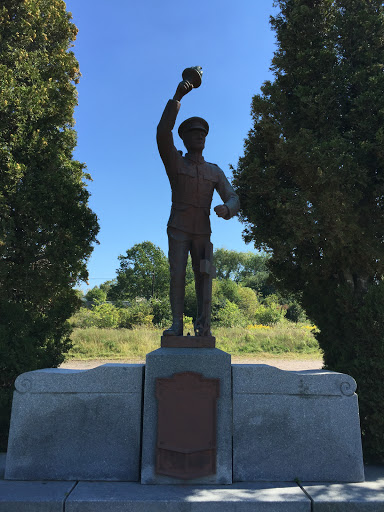 Statue of Man Holding Torch With Cross