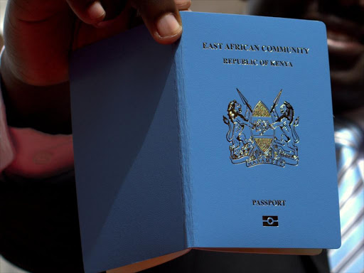 An immigration staffer holds an e-passport at Nyayo House