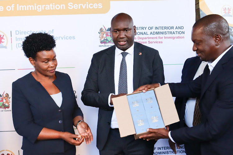 Immigration and Citizen Services Principal Secretary Julius Bitok (centre) and Immigration Services Director General Evelyn Cheluget (left) receive passport printing booklets on March 21, 2024.