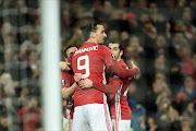 (L-R) Manchester United's Spanish midfielder Juan Mata, Manchester United's Swedish striker Zlatan Ibrahimovic and Manchester United's Armenian midfielder Henrikh Mkhitaryan (R) celebrate after Mata scored the opening goal during the UEFA Europa League round of 16 second-leg football match between Manchester United and FC Rostov at Old Trafford stadium in Manchester, north-west England, on March 16, 2017.