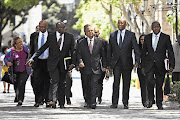 Minister of Finance Pravin Gordhan, centre, and his team arrive at parliament yesterday for his Budget presentation