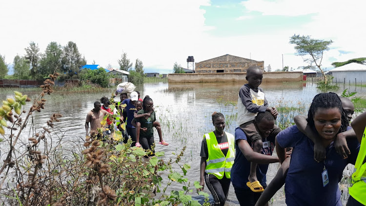 Compassionate Centre for Families officers rescue stranded children who were displaced after backflow from Lake Victoria caused flooding in Dunga in Nyalenda B ward, Kisumu central sub-county.