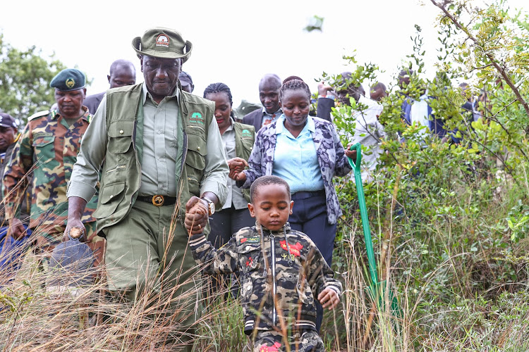President William Ruto with a young boy during the national tree planting day at Kiambicho Forest Karua Hill A, Murang'a County, on May 10, 2024.