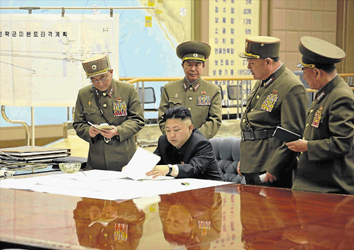 This official photo shows North Korea's Kim Jong-un in an emergency meeting with top officers