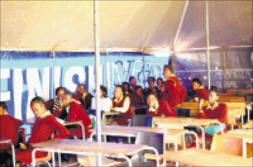 TENT TEACHING: Pupils at Bafedile Junior Secondary School at Maubane in North West are being taught in tents because a contractor ripped off the roofs of their classrooms. Pic. Peggy Nkomo. 21/07/08. © Sowetan.