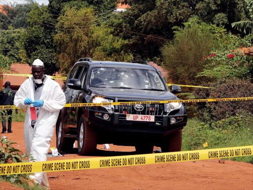 Uganda's police investigators are seen working at the cordoned off scene of crime where unknown gunmen killed the spokesman for Uganda's police force Felix Kaweesi and two other victims, in capital Kampala, Uganda March 17, 2017. REUTERS/James Akena