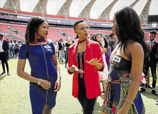 BEST FOOT FORWARD: Auditions for a new SABC presenter were held at the Nelson Mandela Bay Stadium yesterday. Host of Presenter Search on 3, Pabi Moloi, middle, chats to hopefuls Anele Mni, left, and Mbali Mashaqane, right Picture: WERNER HILLS