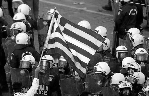 A protester waves a Greek flag at a police cordon following riots in Athens's Syntagma Square earlier this year. With bailouts conditional of deep austerity measures having been implemented, Greece's outlook is bleak. However, say analysts, the long-overdue structural changes being made to the economy are positive Picture: REUTERS