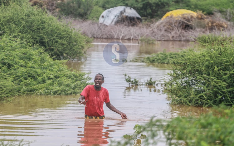 Ali Abdilahi Muhamad, a 50-year-old elder at Shimberey Village in Garissa County wades through water after being displaced by floods following heavy downpour in the area on April 26, 2024.