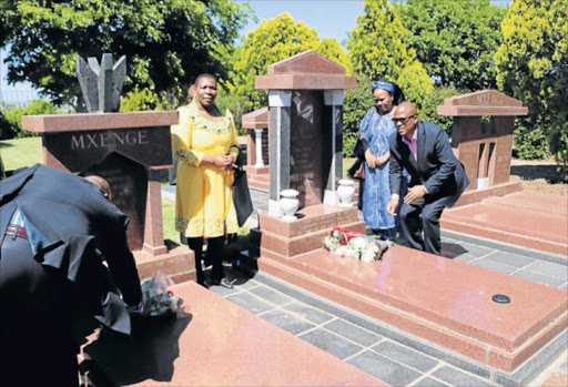 SOLEMN MOMENT: ANC provincial chairman Oscar Mabuyane lays a wreath with his wife Siya at the grave site of anti-apartheid activists Griffiths and Victoria Mxenge in Rhayi village near King William's Town yesterday, while PEC member Nonceba Kontsiwe looks on Picture: THABANG MASEKO
