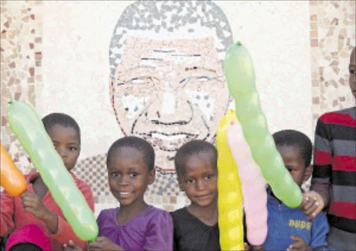 Children at a Madiba mural at the Nelson Mandela Museum in Qunu, Eastern Cape, ahead of the former president's 93rd birthday. Celebrities around the country will be volunteering their time to good causes to celebrate the big day