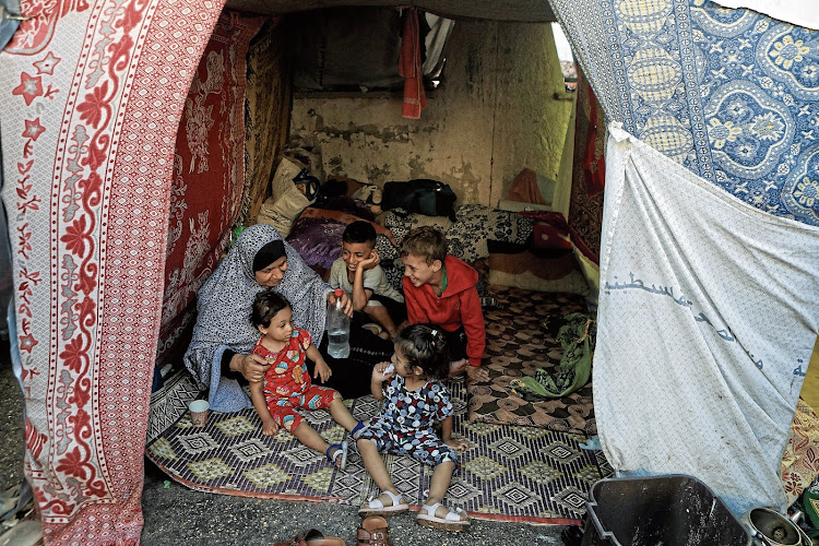 A displaced Palestinian woman sits with her grandchildren in a makeshift shelter at Shifa hospital in Gaza City on November 5. Picture: REUTERS/MOHAMMED AL-MASRI