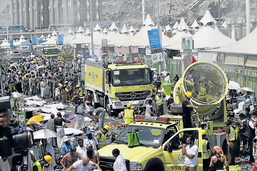 GRIM AFTERMATH: Members of the Saudi emergency services move among the bodies of those killed in a stampede as pilgrims look on, in the Mina neighbourhood of Mecca, Saudi Arabia on Thursday Picture: EPA