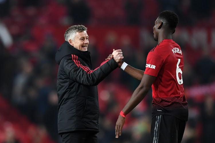 Ole Gunnar Solskjaer, Interim Manager of Manchester United and Paul Pogba of Manchester United celebrate following their sides victory in the Premier League match between Manchester United and Huddersfield Town at Old Trafford on December 26, 2018 in Manchester, United Kingdom.