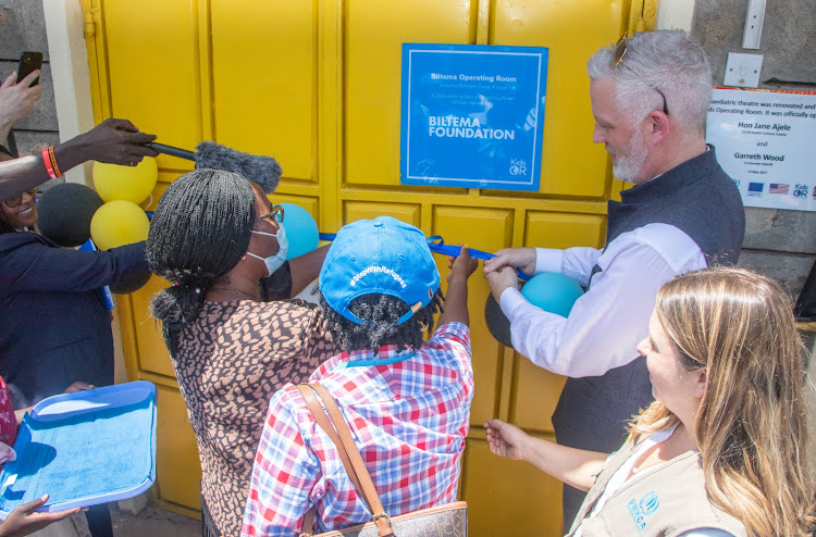 Kids Operating Room founder Garreth Wood (right) cuts a ribbon to officially open the first paediatric room in a refugee camp, based at the Kakuma General hospital. He's joined by Jane Ajele, CEC health Turkana County, on the extreme left.