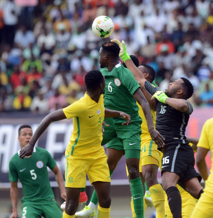 Wilfred Ndid of Nigeria contest the ball Itumeleng Khune of South Africa during the 2019 Africa Cup of Nations Qualifying match between Nigeria and South Africa at Godswill Akpabio International Stadium on June 10, 2017 in Uyo State, Nigeria.