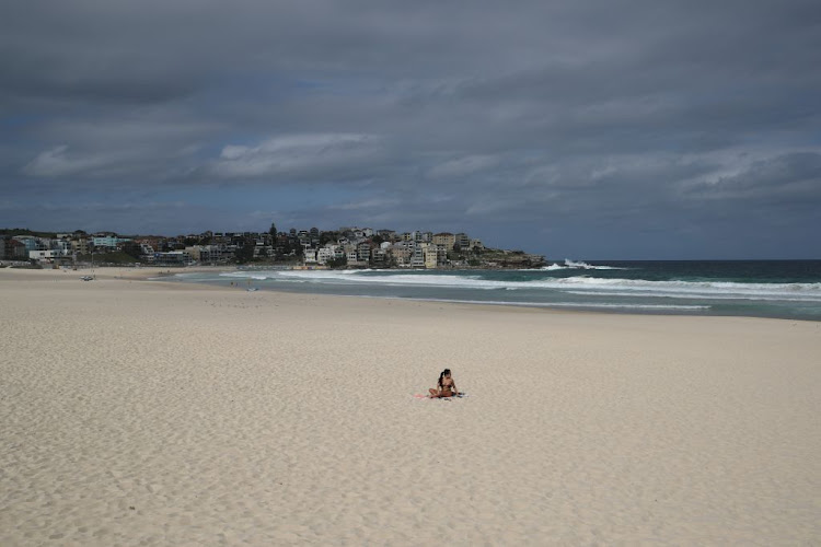 A single sunbather remains following the closure of Bondi Beach, in Sydney, March 21 2020, after thousands of peopled flocked there in recent days, defying social distancing orders to prevent the spread of the coronavirus.