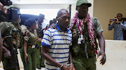 Paul Mackenzie, a Kenyan cult leader accused of ordering his followers, who were members of the Good News International Church, to starve themselves to death in Shakahola forest, is escorted to the Malindi law courts in Malindi, Kilifi, Kenya, on January 17 2024. 