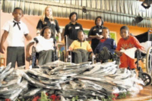 BAGS OF HELP: Damelin students with children at the Ithembelihle LSEN School. Pic. Unknown