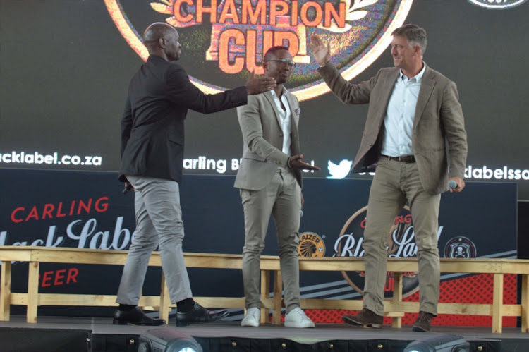 Kaizer Chiefs Steve Komphela (L), TV personality Andile Ncube and Orlando Pirates head coach Kjell Jonevret (R) during the Carling Black Label Champion Cup launch at Park Station on May 02, 2017 in Johannesburg, South Africa.