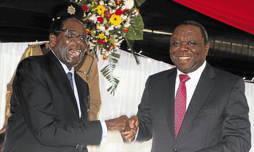 Zimbabwe President Robert Mugabe jokes with Prime Minister Morgan Tsvangirai after signing Zimbabwe's new constitution into law in Harare. File photo.