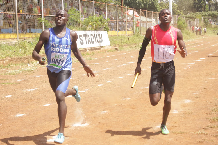 Daniel Wasike (L) of Riooga Secondary and Simeon Araka of Keberesi in 4x100m relay action