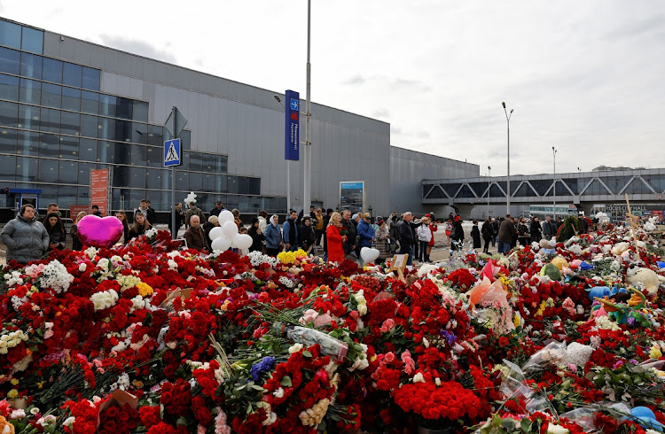 People come to lay flowers at a makeshift memorial near the Crocus City Hall after a deadly attack on the concert venue outside Moscow, Russia, on March 26 2024. Picture: REUTERS/EVGENIA NOVOZHENINA