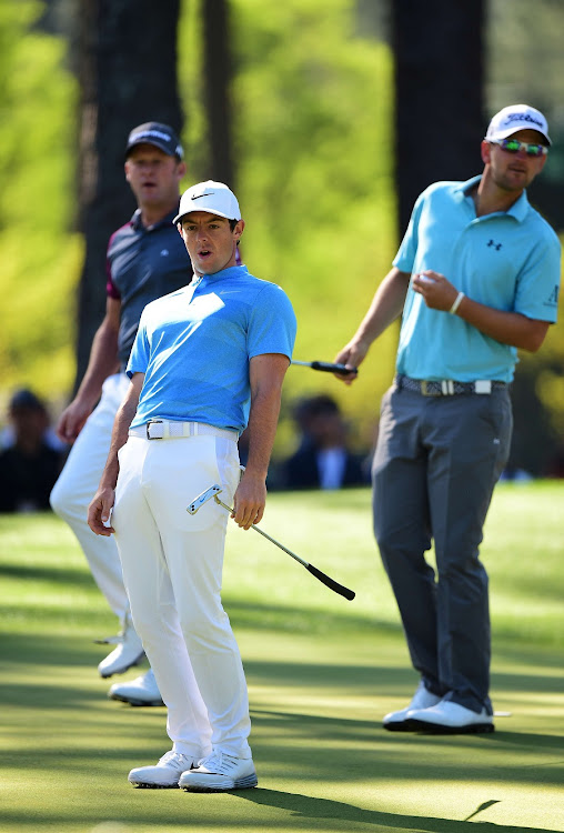 FOCUSED: Rory McIlroy, centre, follows the path of the ball during a practice round for the Masters yesterday, with Jamie Donaldson of Wales, left, and Austria’s Bernd Wiesberger equally intent on the outcome. Picture: AFP