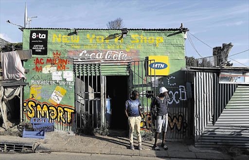 TRAILBLAZERS: Residents outside a spaza shop in Cape Town's Imizamo Yethu township. Spazas have been reshaping the national retail landscape away from the media glare and researchers, tapping into underserviced markets.