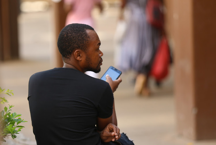 A man checks his cellphone in Harare, Zimbabwe. Life is slowly returning to normal as lockdown measures ease. File photo.