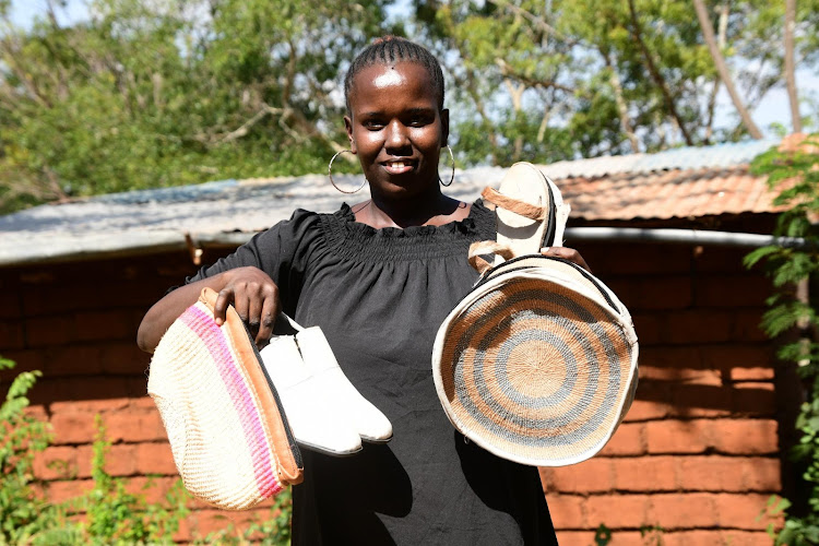 Agness Mbala shows off some of the leather products produced by the youth group. They make belts, knife handles, key holders, dog collars and muzzles, sandals and gloves