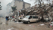 People in front of collapsed buildings after the earthquake in Kahramanmaras, Turkey on February 6 2023. File photo. 
