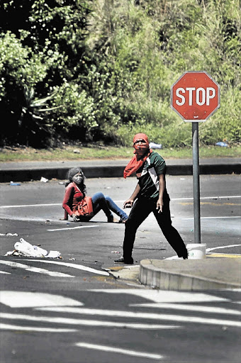 A non-striking University of KwaZulu-Natal student falls to the ground at the Westville campus after she was caught in crossfire during clashes between protesters and police. File photo.