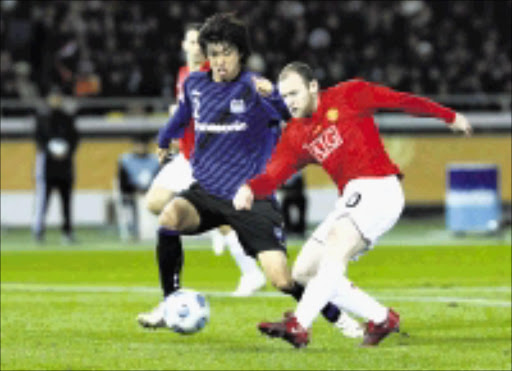 ON TARGET: United's Wayne Rooney, right, outruns Gamba Osaka's Sota Nakazawa to score a goal during the Fifa Club World Cup semifinal match in Yokohama, south of Tokyo, yesterday. 18/12/08. Pic. Kim Kyung-Hoon. © Reuters.