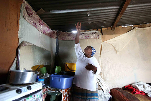 RUINED: Nompumelelo resident Sisikazi Skellem shows the areas in her roof and walls where the weekend’s heavy rains ruined her furniture and carpets