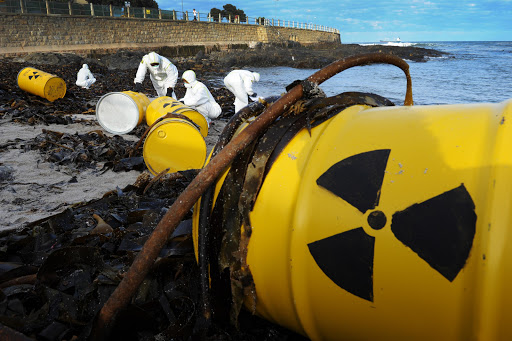 Activists from Greenpeace Africa place look-a-like radioactive barrels on the beach in Three Anchor Bay, Cape Town.
