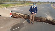 A metro police officer demonstrates the severity of the damage to the road in Soweto. Both lanes have been closed and motorists are using the Rea Vaya lane. 
