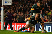 South Africa's scrum half and captain Fourie du Preez (down) celebrates with South Africa's wing Bryan Habana after scoring his team's first try during a quarter final match of the 2015 Rugby World Cup between South Africa and Wales at Twickenham stadium, southwest London, on October 17, 2015.