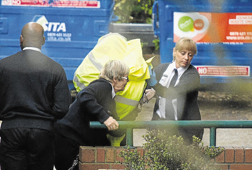 HIDDEN: Tania Clarence is shielded as she is led from a prison van to Wimbledon Magistrate's Court, where she was charged with the murder of her three disabled children