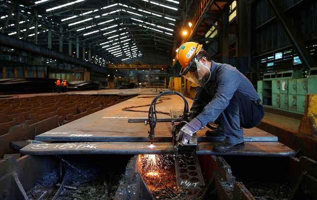 A worker cuts steel plates inside a China Steel Corporation factory. Picture: REUTERS