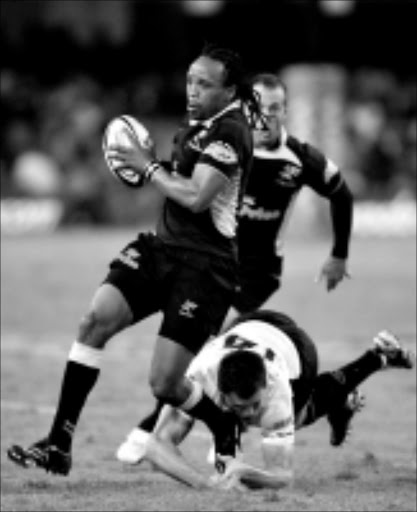 HEEL! The Sharks' Odwa Ndungane bursts through a tackle from the Brumbies' Adam Ashley-Cooper during the Super 14 match at Kings Park Rugby Stadium in Durban last weekend. The Sharks will tackle the Wellington Hurricanes this weekend. 28/03/2009. © Gallo Images. Pic. Anesh Debiky.